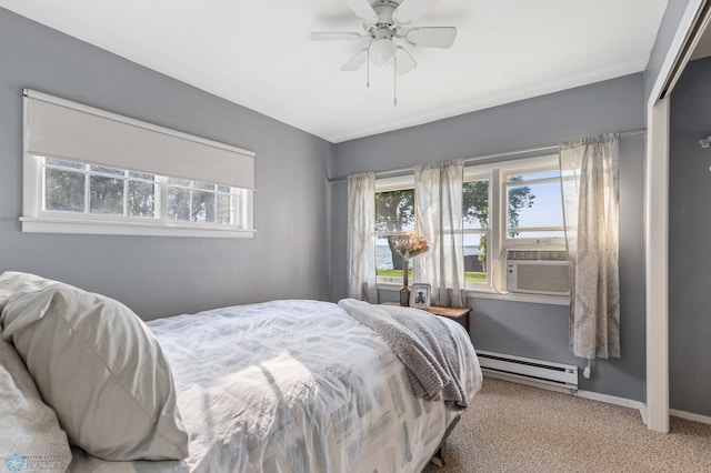 carpeted bedroom with a baseboard heating unit, ceiling fan, a closet, and cooling unit