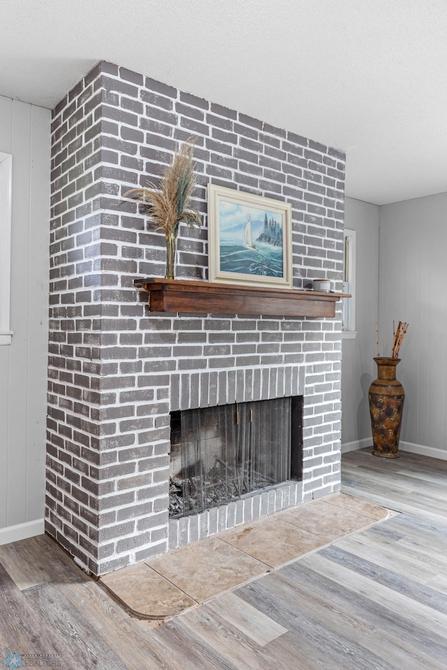 interior details with a fireplace, a textured ceiling, and wood-type flooring