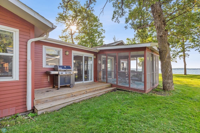 wooden terrace featuring area for grilling, a sunroom, a yard, and a water view