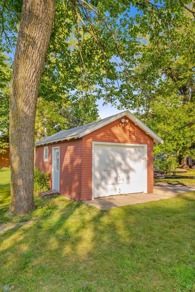 view of outdoor structure featuring a garage and a lawn