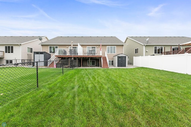 rear view of property with a yard, a storage shed, and a deck