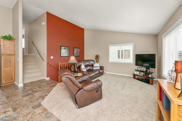 living room featuring a textured ceiling, plenty of natural light, vaulted ceiling, and dark colored carpet