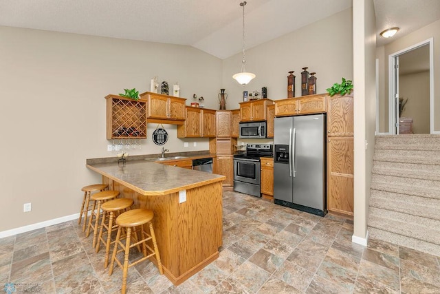 kitchen with a kitchen breakfast bar, appliances with stainless steel finishes, hanging light fixtures, kitchen peninsula, and lofted ceiling