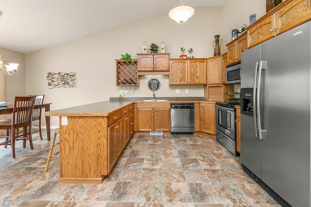 kitchen featuring vaulted ceiling, kitchen peninsula, sink, hanging light fixtures, and appliances with stainless steel finishes