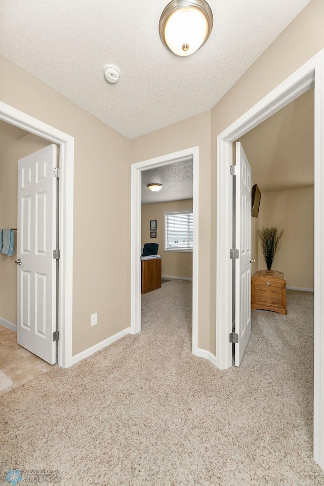 interior space with a textured ceiling and light carpet