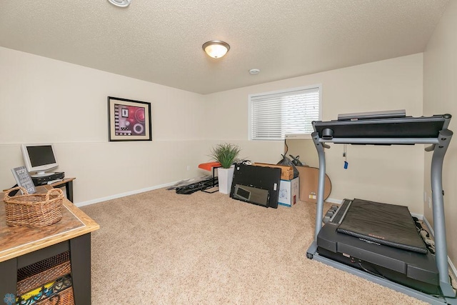 exercise area featuring carpet flooring and a textured ceiling