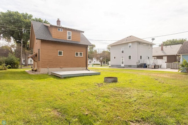 rear view of property featuring a yard, a patio, and a deck