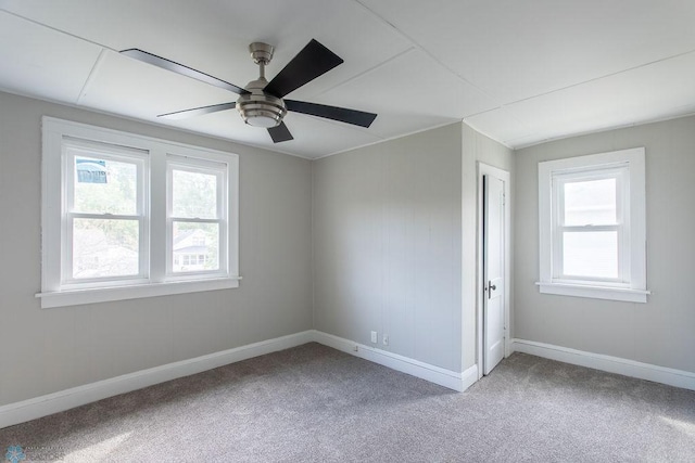 carpeted spare room featuring ceiling fan