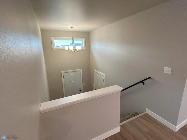 staircase featuring a notable chandelier and hardwood / wood-style flooring