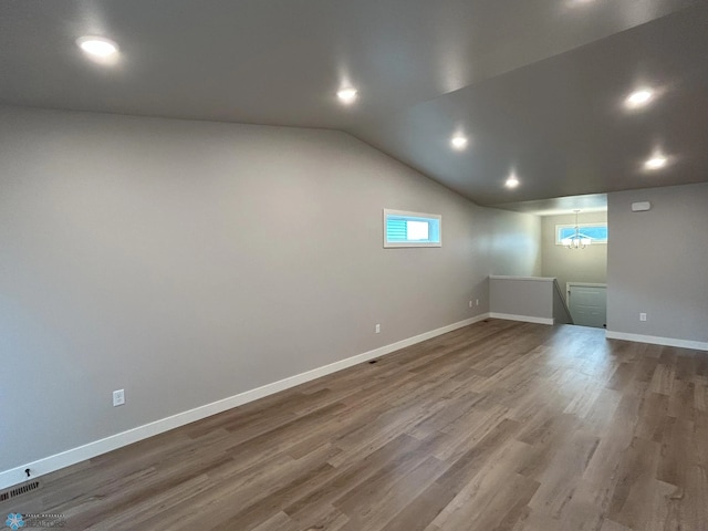 basement with wood-type flooring and a notable chandelier