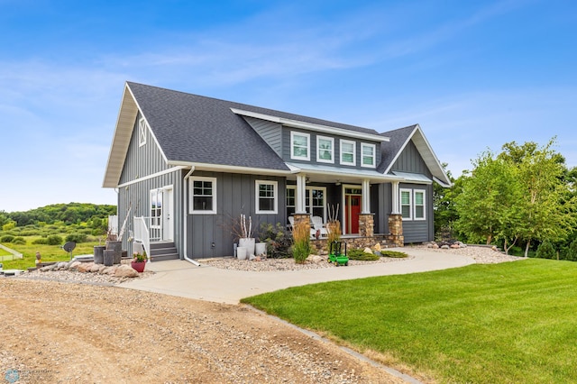 rear view of property featuring a yard and covered porch