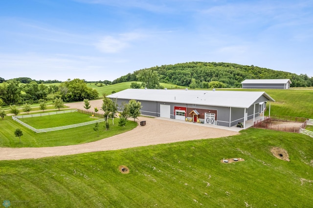 view of front of home with a front lawn and a rural view