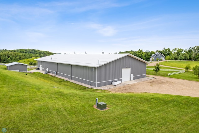 view of side of home featuring an outbuilding and a yard