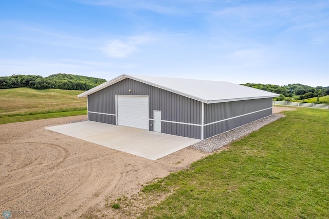 garage featuring a yard and a rural view