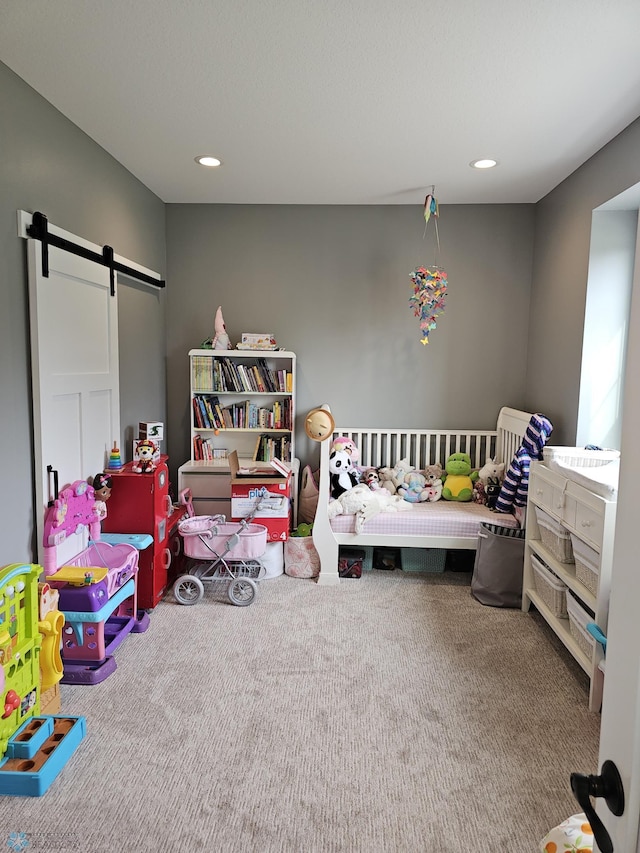 bedroom featuring a barn door and carpet flooring