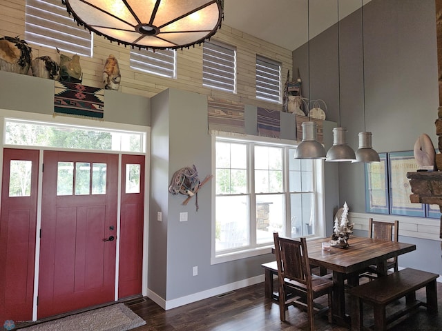 dining space with dark wood-type flooring and a high ceiling