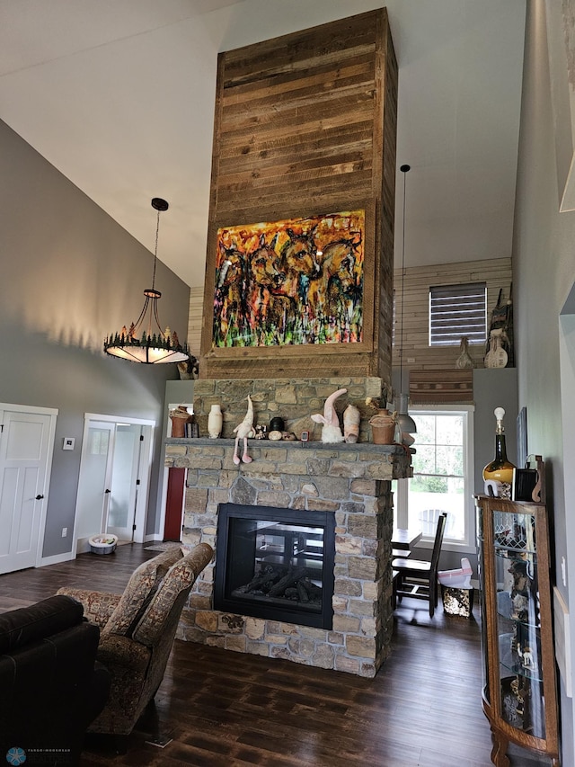 living room featuring a fireplace, dark wood-type flooring, and high vaulted ceiling