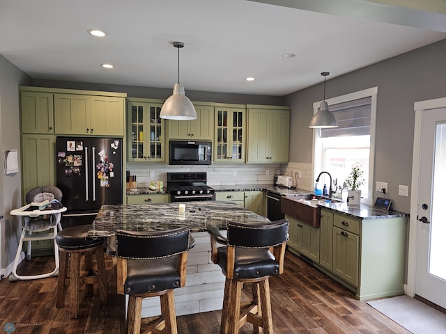 kitchen with dark hardwood / wood-style flooring, black appliances, backsplash, hanging light fixtures, and green cabinetry