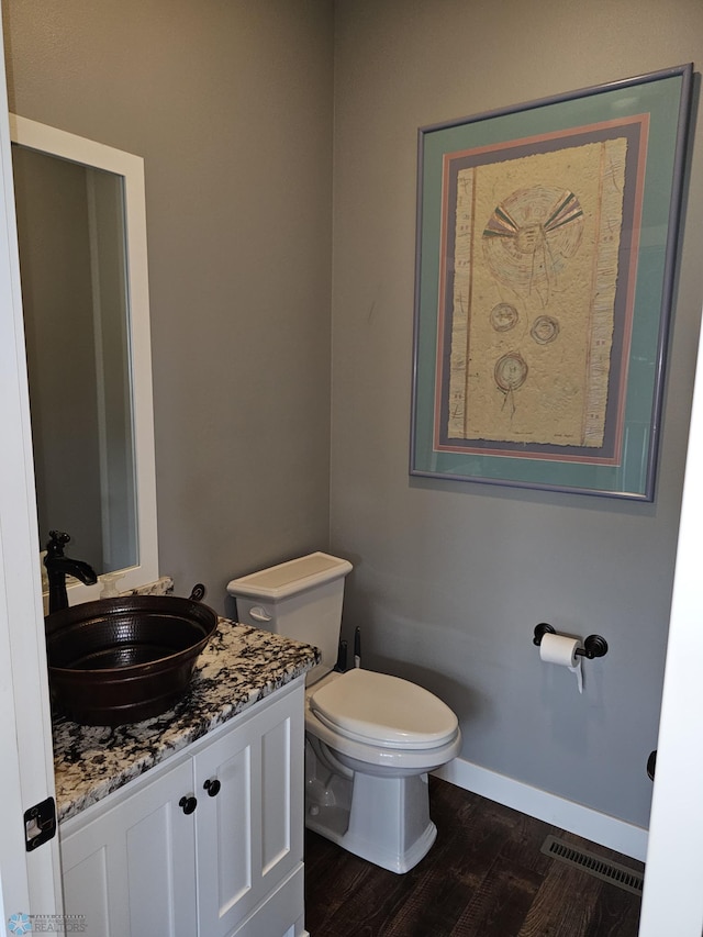 bathroom with wood-type flooring, toilet, and vanity