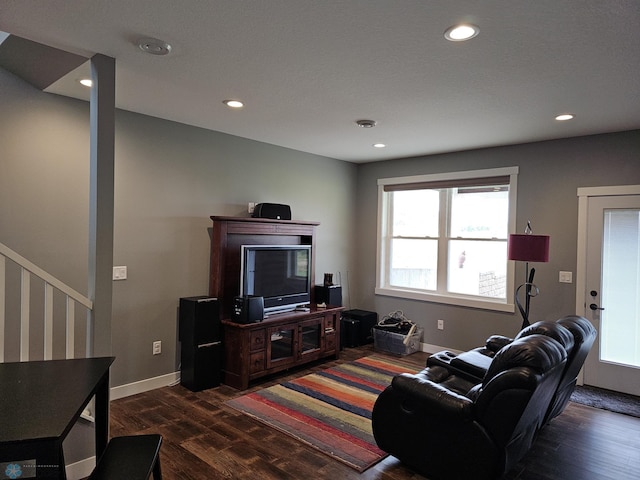 living room featuring dark wood-type flooring and a textured ceiling