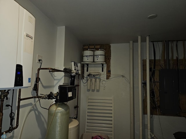 utility room featuring electric panel and tankless water heater