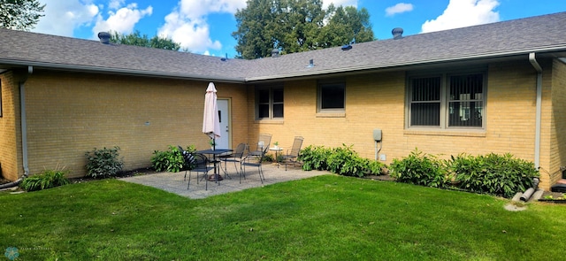 rear view of house with a yard and a patio area