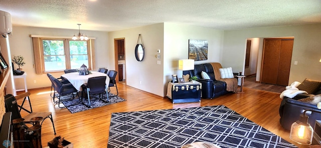 living room featuring a textured ceiling, wood-type flooring, and a notable chandelier