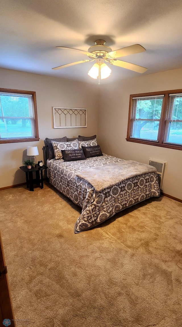 bedroom featuring light colored carpet, a wall unit AC, and ceiling fan