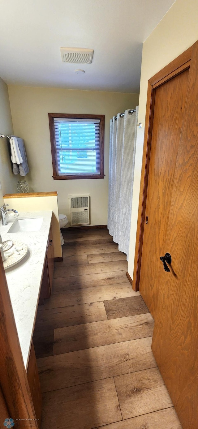 bathroom with vanity, toilet, and hardwood / wood-style flooring