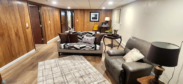 living area with light hardwood / wood-style flooring and wooden walls