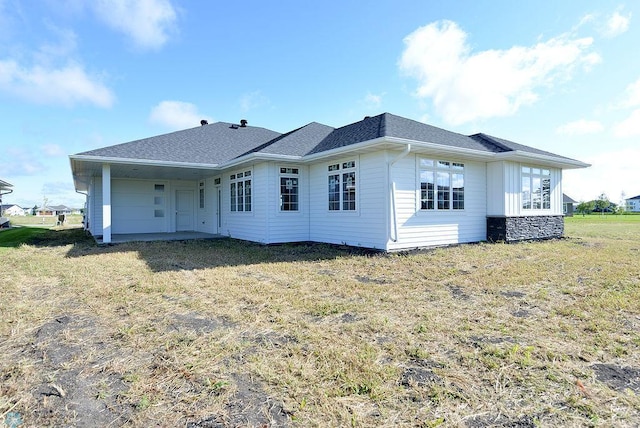 back of house with a lawn