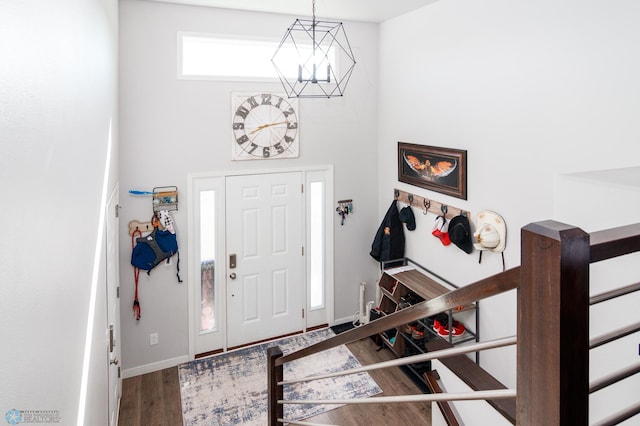 foyer entrance with an inviting chandelier and hardwood / wood-style flooring