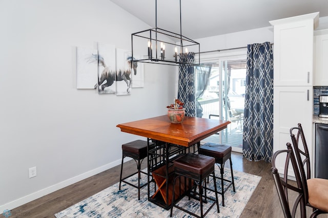 dining area featuring vaulted ceiling, dark hardwood / wood-style floors, and a notable chandelier