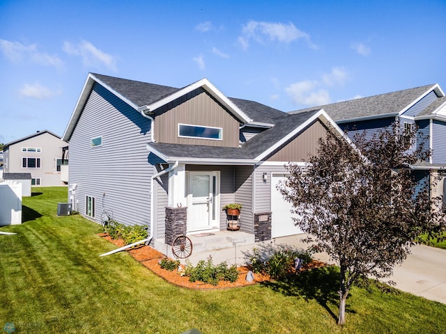 craftsman-style house featuring a front yard, central air condition unit, and a garage