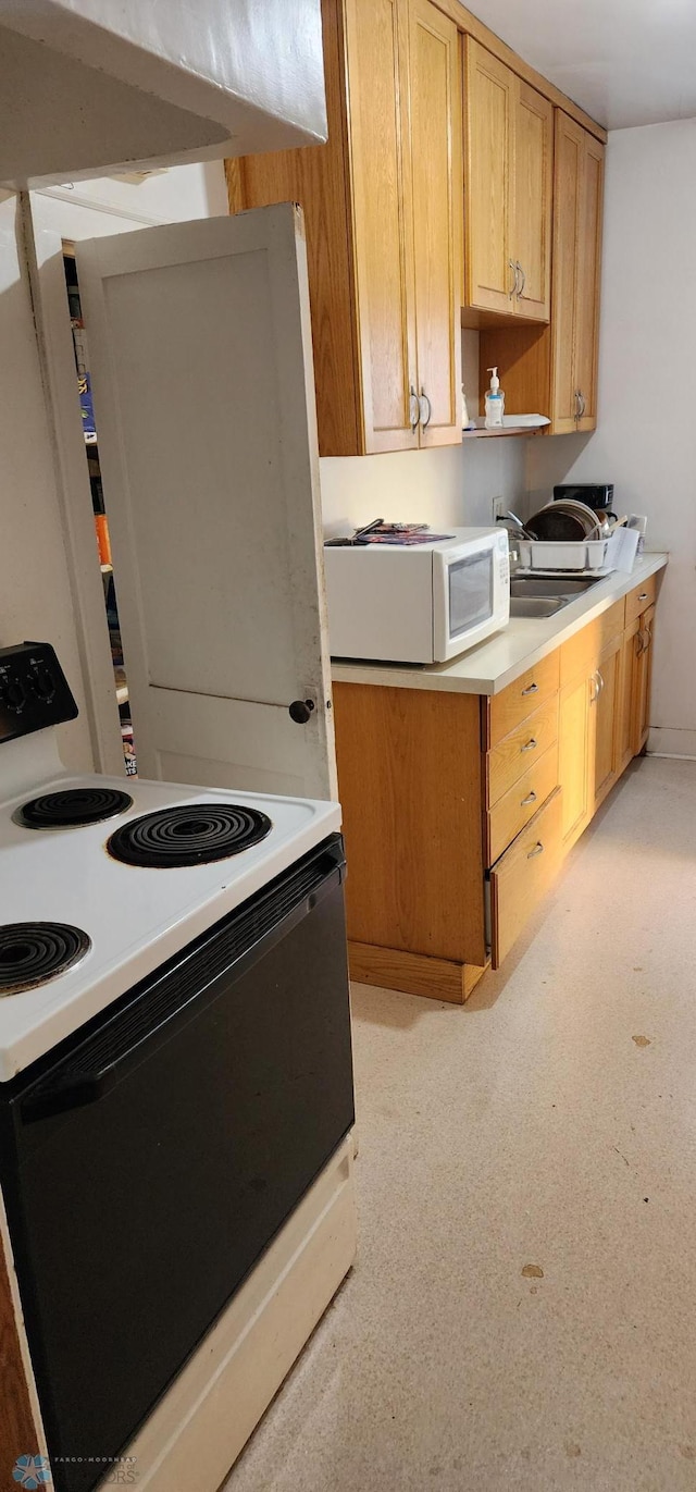 kitchen featuring white appliances and exhaust hood