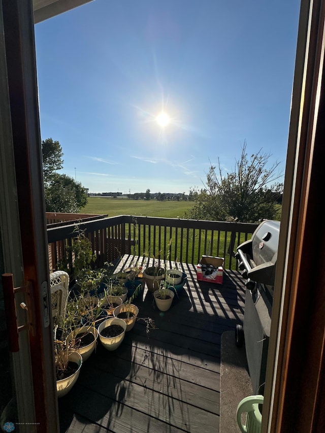 wooden balcony featuring grilling area, a rural view, and a wooden deck