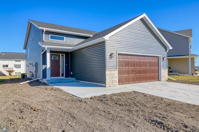 view of front of house featuring a garage and central AC unit