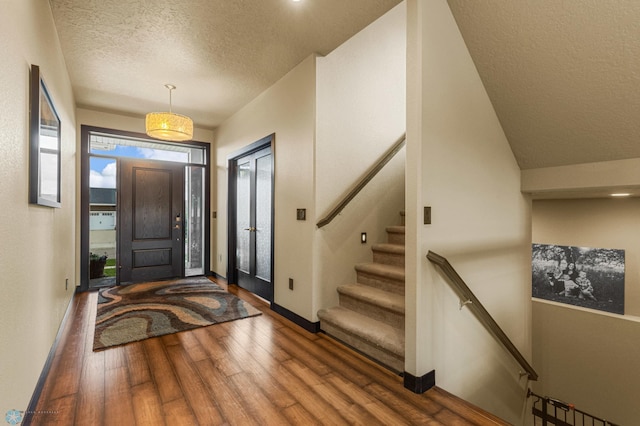 entrance foyer with dark wood-type flooring and a textured ceiling