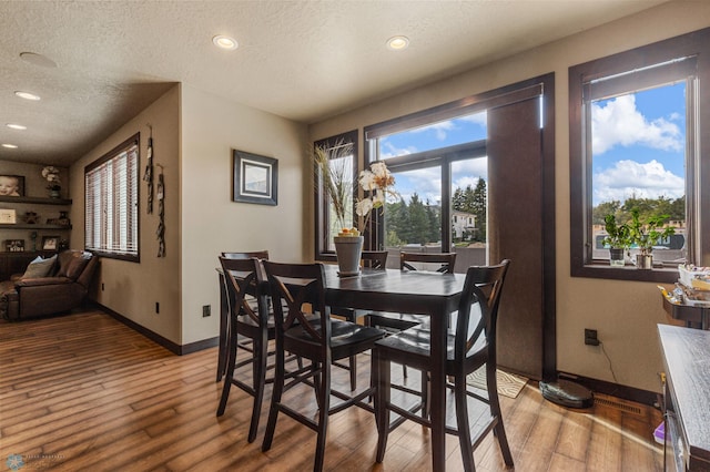 dining room featuring a textured ceiling and hardwood / wood-style floors