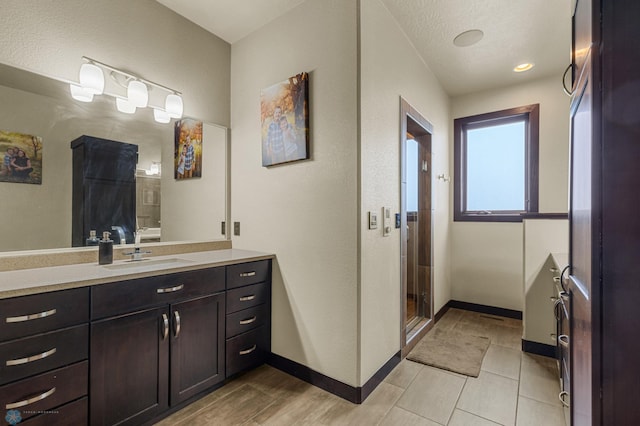 bathroom featuring an enclosed shower, a textured ceiling, and vanity