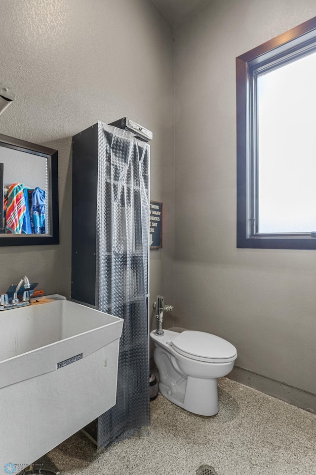 bathroom with toilet, sink, and a textured ceiling