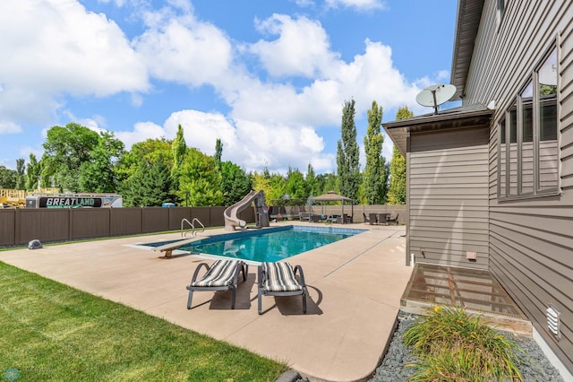 view of swimming pool with a water slide and a patio