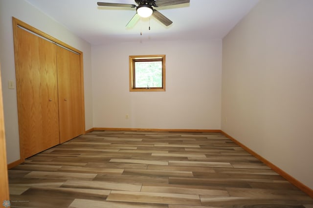 unfurnished bedroom featuring light hardwood / wood-style floors, ceiling fan, and a closet