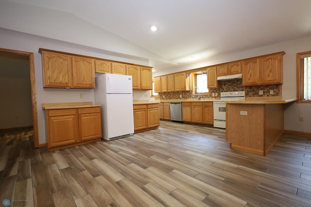 kitchen featuring hardwood / wood-style flooring, vaulted ceiling, white appliances, sink, and kitchen peninsula