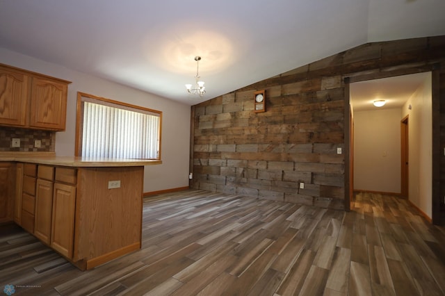 kitchen featuring lofted ceiling, a chandelier, kitchen peninsula, and dark hardwood / wood-style floors