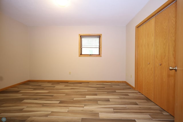 unfurnished bedroom featuring light hardwood / wood-style floors and a closet