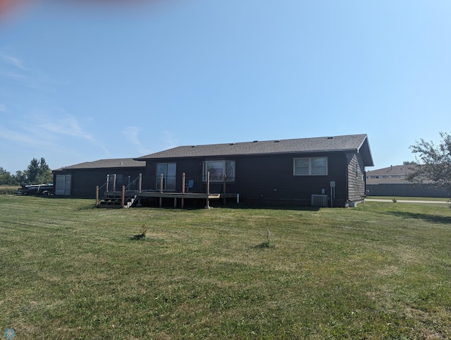 back of property with a yard, a wooden deck, and central AC