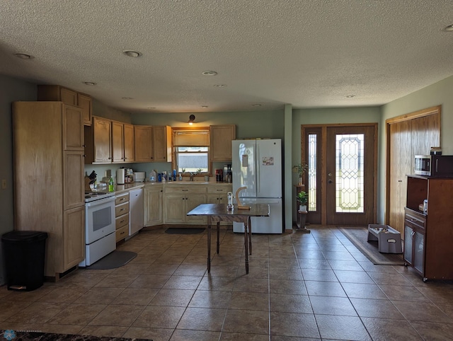 kitchen with dark tile patterned floors, appliances with stainless steel finishes, sink, and a textured ceiling