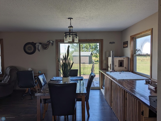 dining space with dark hardwood / wood-style flooring, a chandelier, and a textured ceiling