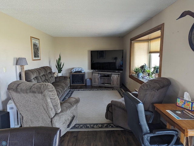 living room featuring a textured ceiling and dark hardwood / wood-style flooring